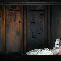 Macbeth hält die am Boden liegende Lady Macbeth in den Armen. Sie scheint leblos.