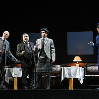 Monsieur Bouc, Hercule Poirot und Oberst Arbuthnot stehen rauchend zusammen, daneben Michel mit einem Schlüssel in den Händen.