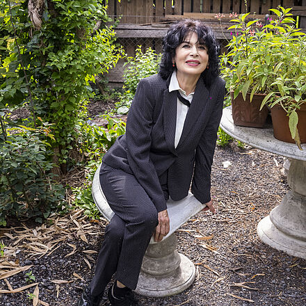 Monika Helfer sitzt im Garten.