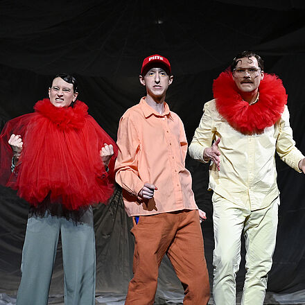 Eine Frau, ein Mann mit Cap, auf dem „Pute“ steht, und ein weiterer Mann schauen in die Kamera.