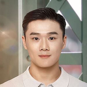 Portraitfoto von Kuang-Yung Chao. Er hat schwarzes kurzes Haar, das er zum Seitenscheitel trägt. Dazu ist er in ein hellgraues Polohemd gekleidet. Hinter ihm stehen die Streben einer grünen Stahlbrücke.