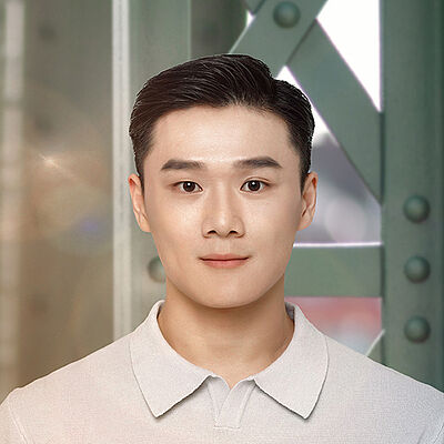 Portraitfoto von Kuang-Yung Chao. Er hat schwarzes kurzes Haar, das er zum Seitenscheitel trägt. Dazu ist er in ein hellgraues Polohemd gekleidet. Hinter ihm stehen die Streben einer grünen Stahlbrücke.