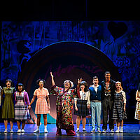 Tracy Turnblad und Link Larkin singen gemeinsam mit den Motormouth Kids und Motormouth Maybelle. Sie halten sich dabei an den Händen und tragen Kleidung der 60er. Den Hintergrund bildet eine große Schallplatte mit der Aufschrift „Motormouth“ und ein Graffito.