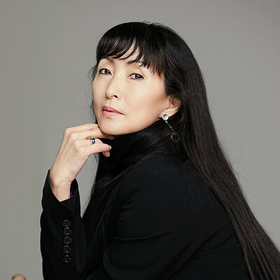Portraitfoto von Young Soon Hue. Sie hat schwarze lange Haare und sie trägt einen schwarzen Blazer.