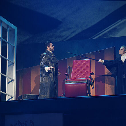 Der Protagonist steht im Friseursalon. Ein Mann zeigt mit einem Stock auf den Protagonist.