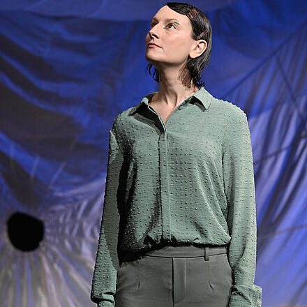 Eine Frau in Grün schaut nach oben.