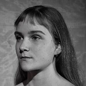 Schwarzweißes Portraitfoto von Olivia Rose Sommer-Mortensen. Sie blickt nach links. Sie trägt ihr Haar offen, ihr kurzer Pony hängt ihr ins Gesicht.