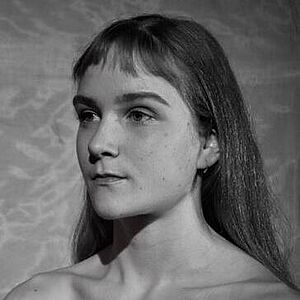 Schwarzweißes Portraitfoto von Olivia Rose Sommer-Mortensen. Sie blickt nach links. Sie trägt ihr Haar offen, ihr kurzer Pony hängt ihr ins Gesicht.