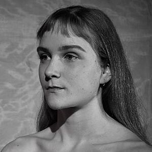 Schwarzweißes Portraitfoto von Olivia Rose Sommer-Mortensen. Sie blickt nach links. Sie trägt ihr Haar offen, ihr kurzer Pony hängt ihr ins Gesicht.