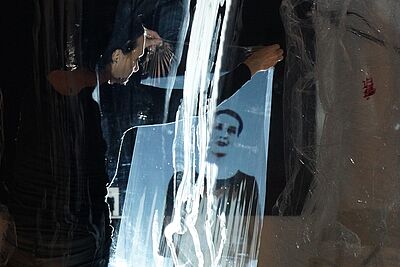 Foto der Künstlerin anna.laclaque, die ein Kunstwerk von sich in den Händen hält und es betrachtet.