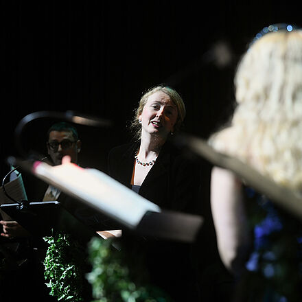 Zwei Personen stehen am Notenständer, sie schauen sich an 