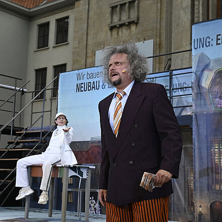 Ein Mann hält Geldscheine in der Hand. Im Hintergrund erkennt man eine Person.