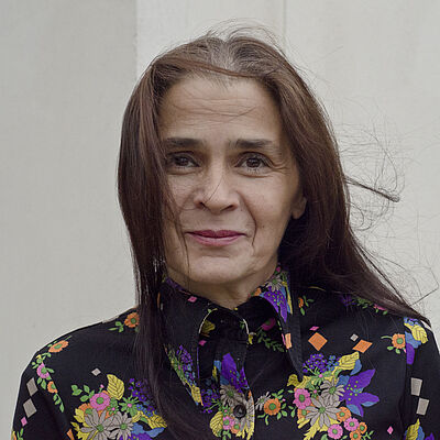 Portrait von Toula Limnaois in bunt geblümter Bluse