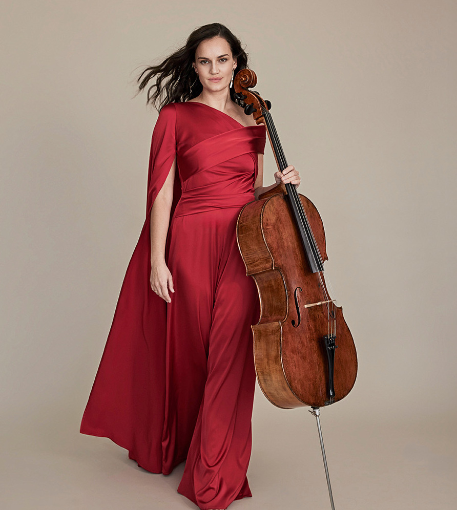 Foto von Raphaela Gromes. Sie hält eine Cello in ihrer Hand und sie trägt ein rotes Abendkleid.