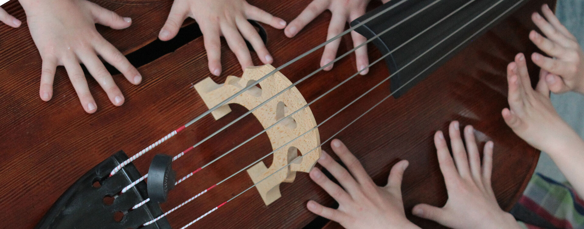 Kinderhände liegen auf Kontrabass