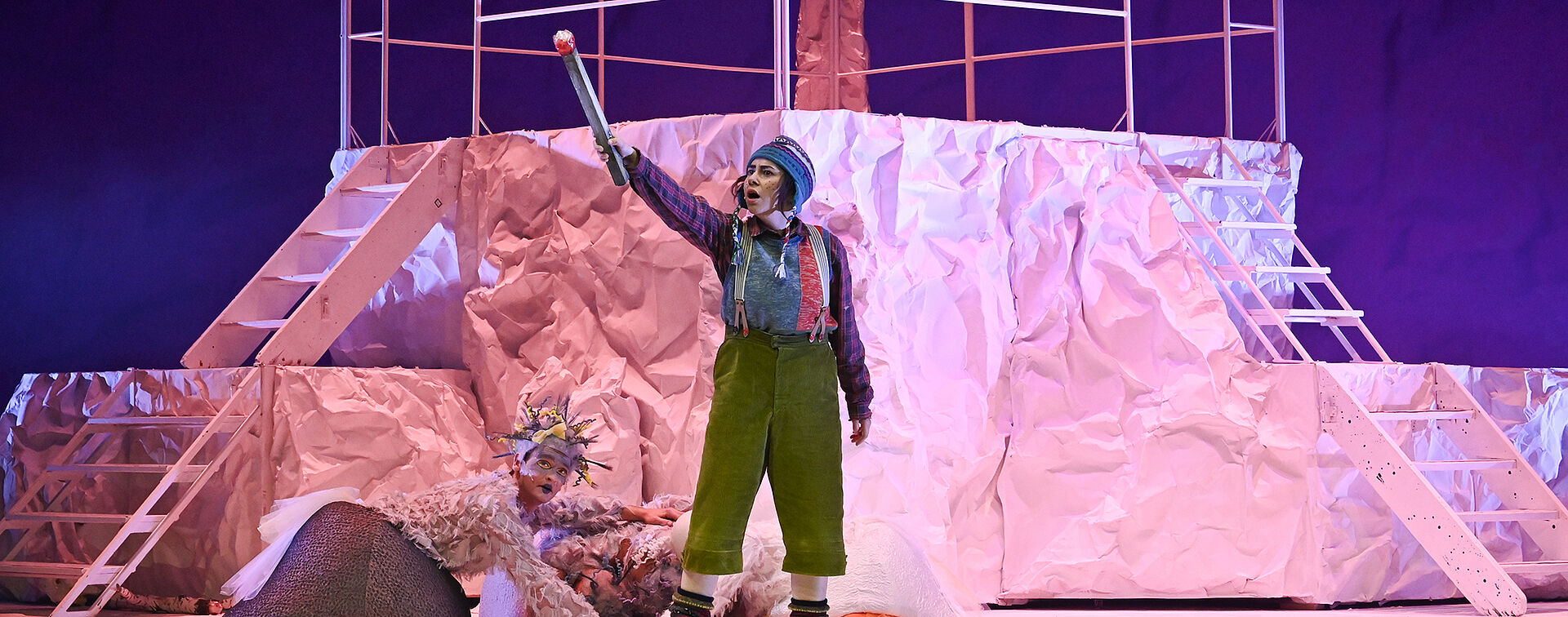 Die kleine Person hält ein Streichholz in der Hand. Hinter ihr liegen mehrere Gänse